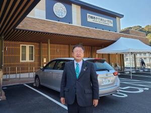 木材をふんだんに利用した温かみのある外観の「四国西予ジオミュージアム」の建物の前に立つ市長の写真