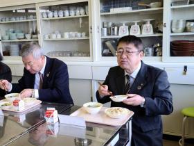 市長と他の市職員が中学校の教室で、シンガポールの給食を食べている写真
