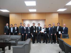 壁際で要望書を一緒に持つ市長と男性1名、関係者の男性11名が横一列に並ぶ記念写真