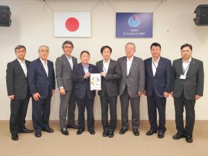国旗がかけられた壁の前で、市長と男性で要望書を持ち、その両脇に3名ずつの関係者の方々が並んで撮影した写真