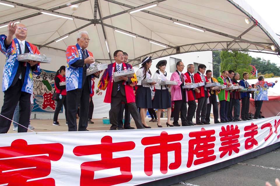 舞台上から餅まきをする様子の市長や関係者の方々の写真