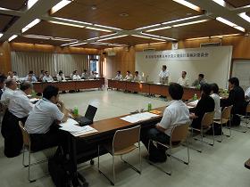広い会議室に、ロの字型で長机が囲まれた席に関係者達が座っており、市長の話を聞いている写真