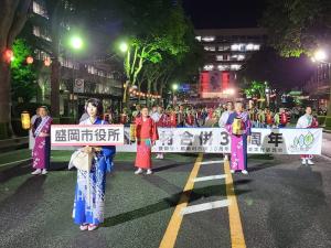 「盛岡市役所」という看板を持った女性を先頭に、道路の真ん中を進む市長と参加者たちの写真