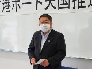 ホワイトボードの前で手紙を持ち話をする様子のマスクをした市長の写真