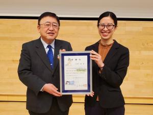 青いネクタイを身に着けた市長と、宮古市地域おこし協力隊の上之原良美さんが一緒に額縁を持ち正面に向け、笑顔で写っている写真