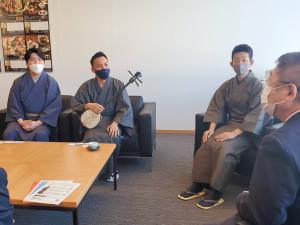 市長が高井賢太郎さん、三線を持った棚原健太さん、町田倫士さんと座って、話をされている写真