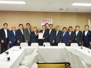 要望書を一緒に持つ市長と男性1名、関係者の男性10名が横一列に並ぶ記念写真