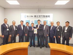 「国土交通省 東北地方整備局」のバックパネルの前で、市長と男性で要望書を持ち、その両脇に男性4名ずつが立っている写真