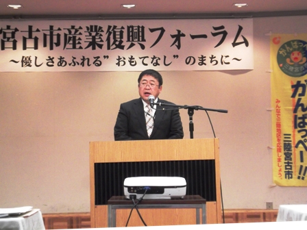 「宮古市産業復興フォーラム」の横断幕の下、演壇に立つ市長の写真