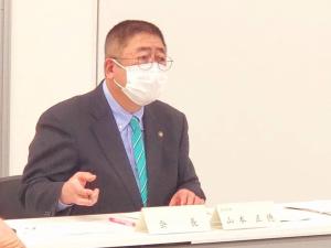 マスク姿で「会長」や名前が書かれた名札が置かれた机に座り、「岩手県立宮古水産高校存続・養殖科新設協議会」で説明をしている写真