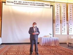 大きなスクリーンが掛けられた会場の中央で、スタンドマイクの前で話をする様子の市長の写真