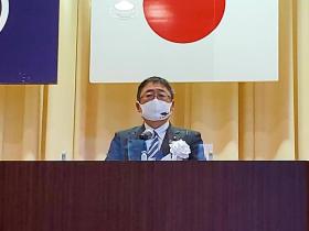 閉校式の壇上に置かれているマイクスタンドの前で市長が閉校する亀岳小学校の功績について、述べている写真