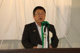 演壇の上に置かれたマイクで話をする市長の写真