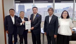 市長含む宮古市の関係者4名と中野英幸復興大臣政務官が横一列に並び、市長と中野英幸復興大臣政務官が要望書を持っている写真