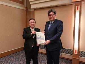 意見交換会の会場の一角で、萩生田光一経済産業大臣と市長が一緒に資料を持っている写真