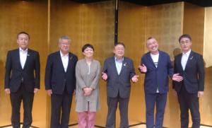 市長を中心に金屏風の前で横一列に並んでいる桂宮治師匠と六花亭遊花師匠と3名の関係者の男性が写っている記念写真