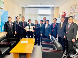 市長含む関係者11名が並び左側にいる男性が要望書を持っている写真