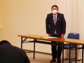 卒業証書授与式で市長が会場に設置された長テーブルの前に立ち会釈をしている写真