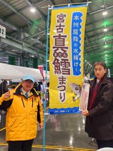 「本州屈指の水揚げ!宮古真鱈まつり」の幟の横で関係者の方がトレーにはいった真鱈を見せながら市長と記念撮影をしている写真