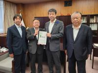 国旗や本棚が設置された室内で、農林水産省の中村裕之副大臣と市長が要望書を一緒に持ち、宮古市議会の橋本久夫議長と宮古商工会議所の大坂文人副会頭が横一列に並んでいる写真