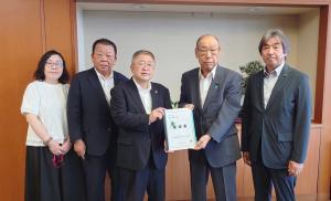市長含む宮古市の関係者4名と豊田俊郎国土交通副大臣が横一列に並び、市長と豊田俊郎国土交通副大臣が要望書を持っている写真