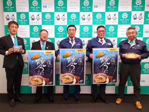 市長と重茂漁協の2名がそれぞれ重茂の焼きうにご飯のポスターを持ち、副市長が箱入りの商品、他の重茂漁協がその商品を盛ったどんぶりをそれぞれ持ち横一列に並んでいる写真