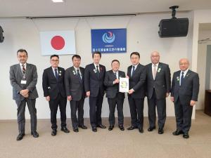 日本国旗と国土交通省 東北地方整備局の旗が壁に吊るされた会場で、左から関係者の男性が4名、要望書を一緒に持つ市長と男性、関係者の男性が2名横一列に並んでいる写真
