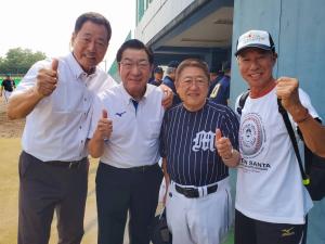 ベンチ横で中畑清さん、大仙市長、柳葉敏郎さんとユニフォーム姿の市長が親指を立てて撮影した写真