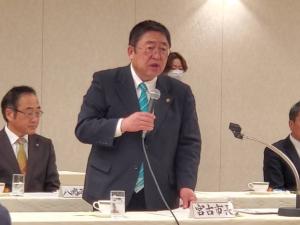 宮古市長と書かれた札が置かれた席から立ち上がり、右手にマイクを持ち話をしている市長の写真