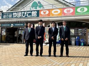 「道の駅やまびこ館」の前で立ち記念撮影をする藤井聡太叡王、菅井竜也八段、森内俊之九段と市長の写真