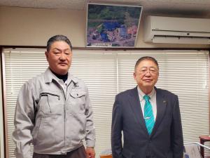 作業着姿の佐々木健治代表取締役社長と市長が並んで記念撮影をしている写真