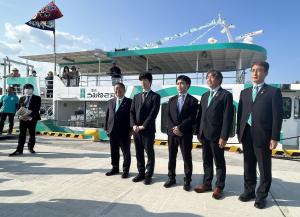 遊覧船うみねこ丸の前で記念撮影をする藤井聡太叡王、菅井竜也八段、森内俊之九段と市長ら男性5人の写真