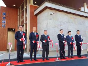 新しい支店の前で市長の他、5人の東北銀行の方々とレッドカーペットの上で、紅白のテープカットをした写真
