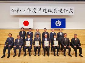 令和2年度派遣職員退任式と書かれた幕の下で、退任される4人がそれぞれ賞状をもち市長と他の職員の方々と並んで撮影した写真