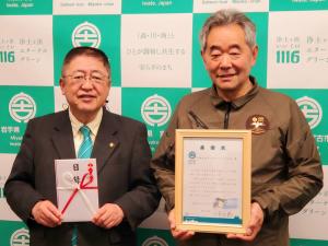 宮古市のバックボードの前で目録を両手で持つ市長と感謝状を両手で持つ株式会社かけあしの会の方が並んでいる写真