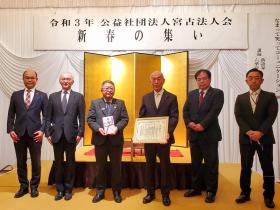 令和3年公益社団法人宮古法人会と書かれた横断幕の下で金色の屏風の前に立ち、市長が寄附金の目録を持ち、法人会の1人が市からの感謝状を持って、計6人で並んで撮影した写真