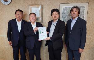 市長含む宮古市の関係者3名と大島一博厚生労働事務次官が横一列に並び、市長と大島一博厚生労働事務次官が要望書を持っている写真