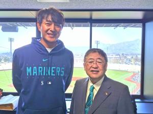 両手を後ろに組み笑顔を浮かべる岩隈久志さんと市長が並んで写っている記念写真