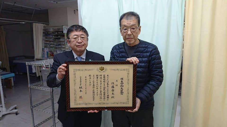 賞状の額縁を一緒に持つ市長と男性の記念写真