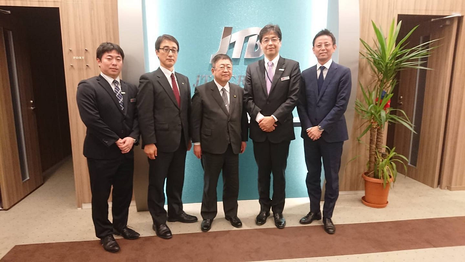 2つの部屋の間の壁にJTBのロゴマークが表示された室内で、3名の株式会社JTBクルーズ事業部の担当者の方々と市長と副市長が横一列に並んでいる写真