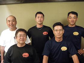 右胸に「みやこ」と書かれたお揃いのTシャツを着た田中敏明第2師団長、日笠玲次郎副師団長、滝澤博文幕僚長と市長が2列で並んでいる写真