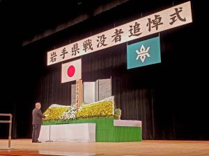 岩手県戦没者追悼式と書かれた横断幕が掲げられたステージの上で、追悼の言葉を述べている市長の写真
