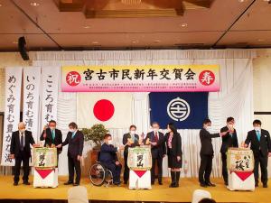 「宮古市民新年交賀会」と書かれた横断幕の舞台上で、市長や関係者が鏡開きをしている写真