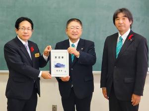 市長を真ん中に3名の男性が並び、市長と左側に立つ男性が要望書を持っている写真