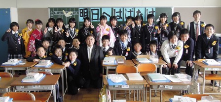 市長が卒業生する小学生達と、教室の後ろに集合して記念撮影する写真