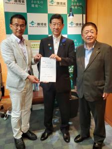 バックパネルの前で山田司郎名取市長と伊藤信太郎環境大臣で要望書を持ち、横に市長が立っている写真