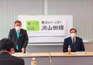 「乗って応援!魅力がいっぱいJR山田線」と書かれたホワイトボードの前に長机があり、市長が立って発言している様子の写真