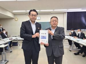 要望書を正面に向け一緒に持つ市長とスーツを着て眼鏡をかけた男性の写真