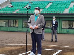 野球場のホームベースのところでスタンドマイクを前に話をする市長の写真