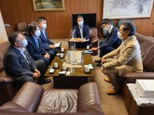 茶色の革張りの椅子が設置された室内で、品川区長の濱野健氏や3名の関係者、宮古市議会の橋本久夫議長と市長が話をしている様子の写真